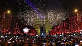 Revellers photograph fireworks over the Arc de Triomphe as they celebrate the New Year on the Champs Elysees, in Paris, France, Wednesday, Jan. 1, 2020.