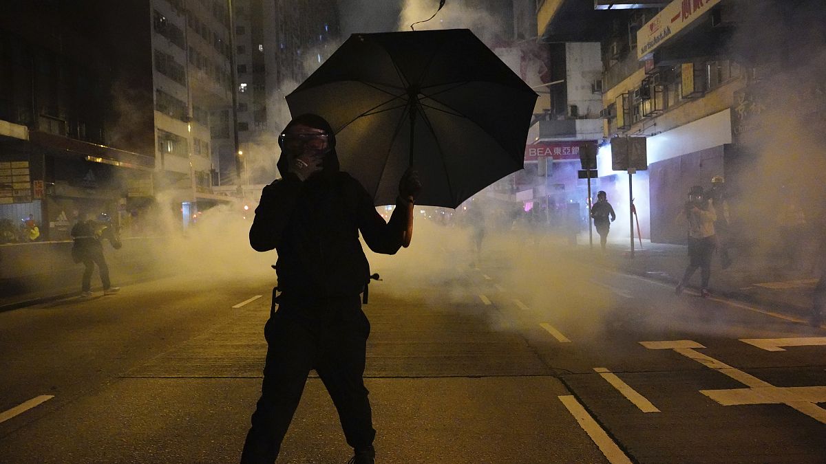 Un manifestante se protege de los gases lacrimógenos en Hong Kong                        