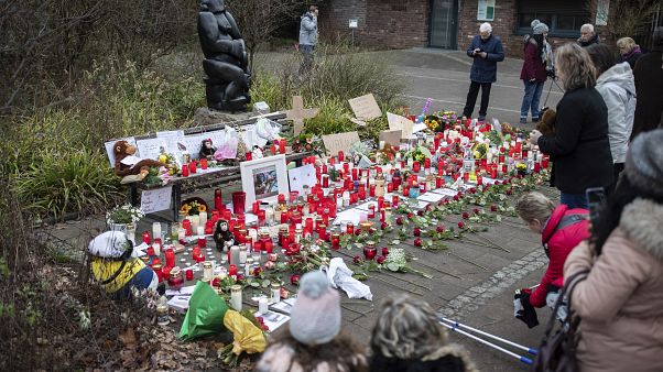 A women lights a candle at the main entrance of the Zoo in Krefeld, Germany, Thursday, Jan. 2, 2020. A women lights a candle at the main entrance of the Zoo in Krefeld, Germany, Thursday, Jan. 2, 2020.