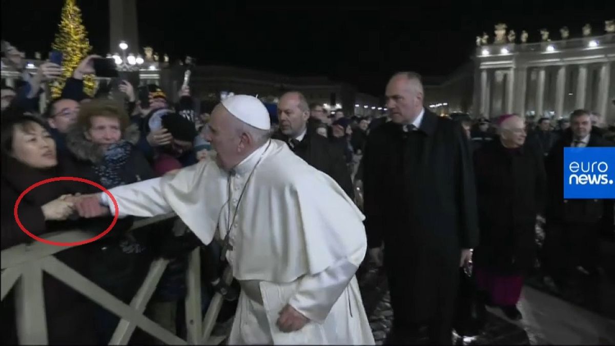 Eine Anhängerin reißt den Papst zu sich