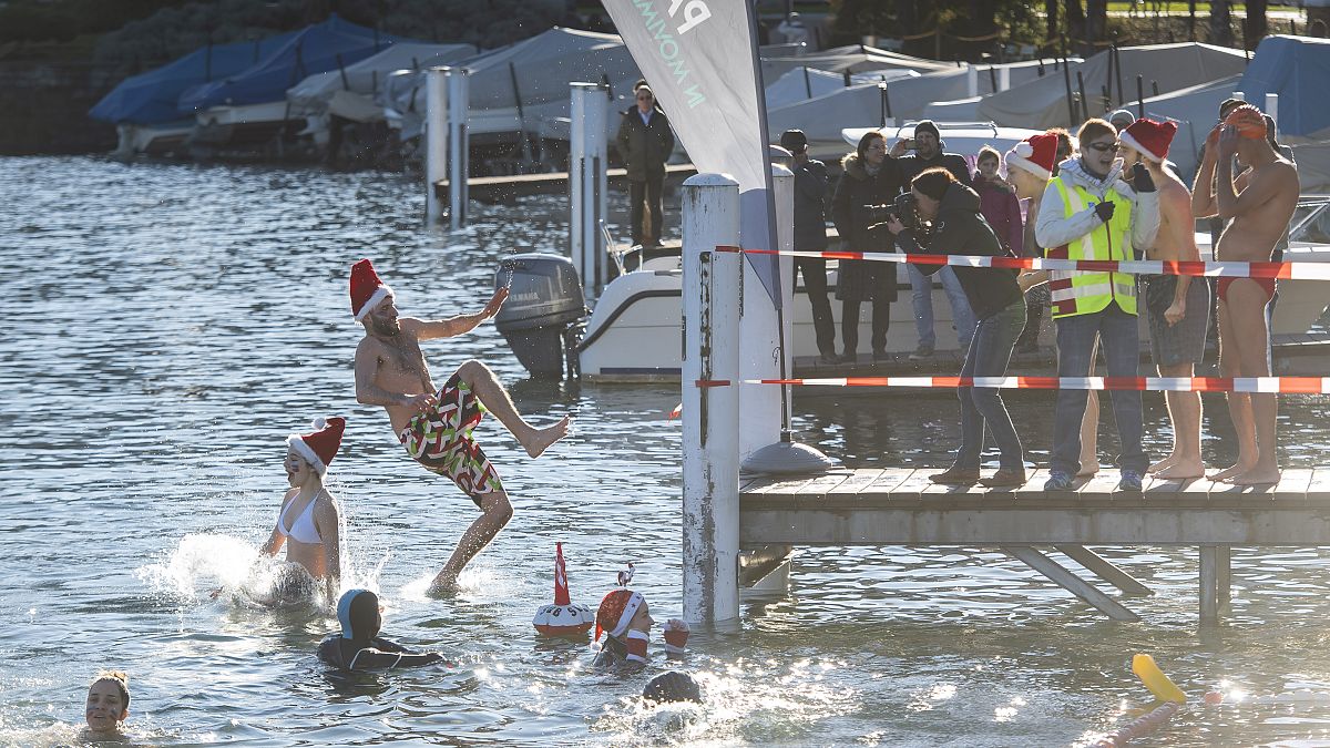 Participants of the annual winter swimming jump into the Lake Lugano on St Stephen's Day in Paradiso, Switzerland, Thursday, Dec. 26, 2019. 