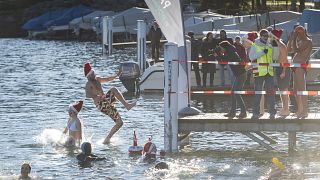Participants of the annual winter swimming jump into the Lake Lugano on St Stephen's Day in Paradiso, Switzerland, Thursday, Dec. 26, 2019. 