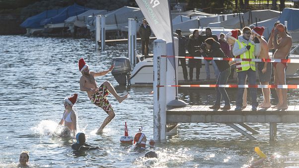 Participants of the annual winter swimming jump into the Lake Lugano on St Stephen's Day in Paradiso, Switzerland, Thursday, Dec. 26, 2019. Participants of the annual winter swimming jump into the Lake Lugano on St Stephen's Day in Paradiso, Switzerland, Thursday, Dec. 26, 2019.