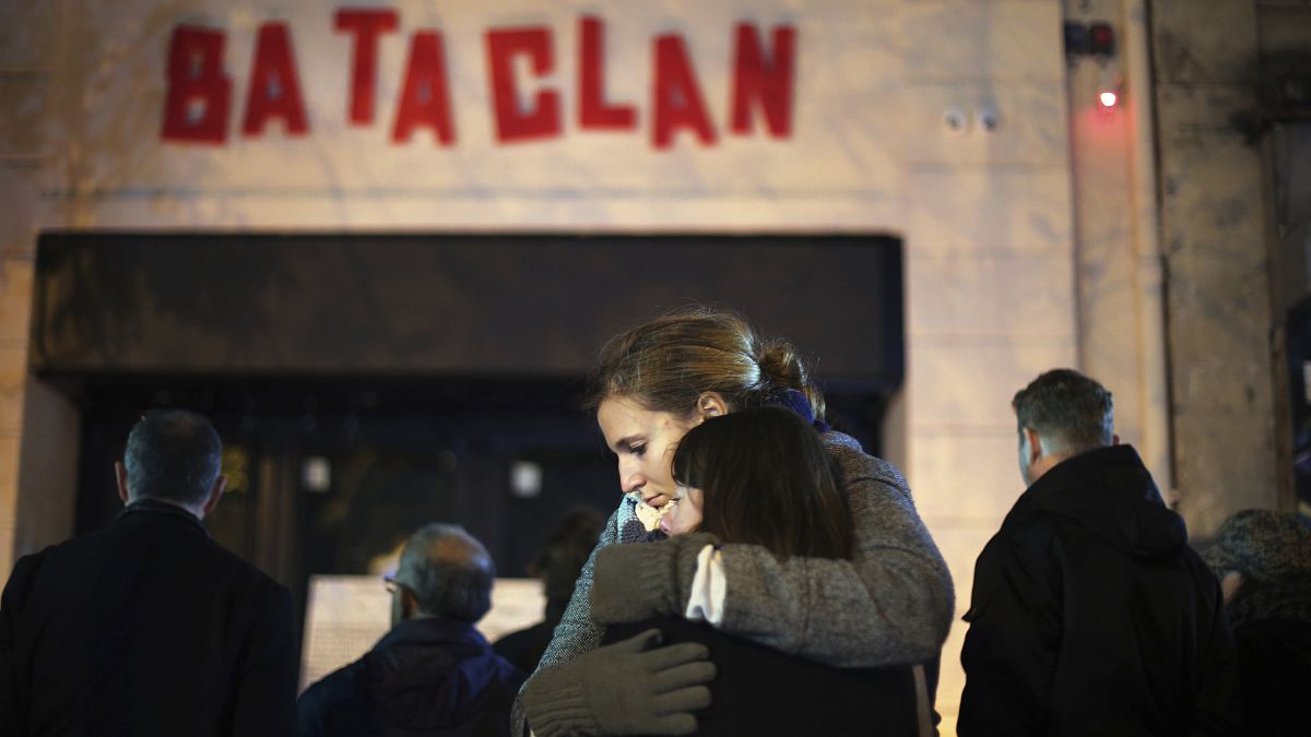 In this Nov. 13, 2016 file photo, women hug in front of the Bataclan concert hall in Paris, as France marked the anniversary of Islamic extremists' coordinated attacks.