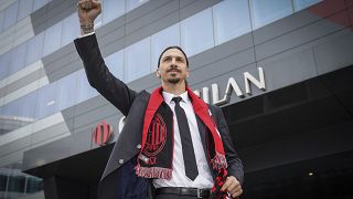 Zlatan Ibrahimovic wears an AC Milan scarf as he acknowledges his fans outside the AC Milan team headquarters, in Milan, Italy, Friday, Jan. 3, 2020.