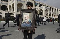 A boy carries a portrait of Iranian Revolutionary Guard Gen. Qassem Soleimani, who was killed in the U.S. airstrike in Iraq