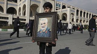 A boy carries a portrait of Iranian Revolutionary Guard Gen. Qassem Soleimani, who was killed in the U.S. airstrike in Iraq