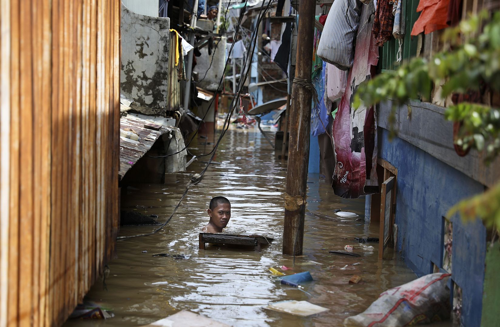 A man swims in flood water in a low-income neighborhood in Jakarta, Indonesia. 2 January 2020. Severe flooding in the capital as residents celebrated the new year has killed s