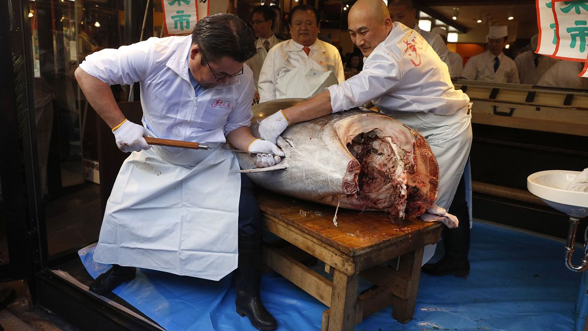 طاهي سوشي يقطع سمكة التونة ذات الزعانف الزرقاء في مطعم في سوق تسوكيجي في طوكيو، 5 يناير 2020 ، بعد بيعها في أول مزاد عام 2020 في سوق أسماك تويوسو بطوكيو.
