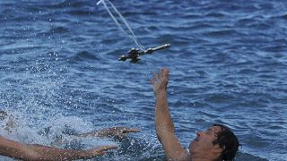 سباح يحاول خطف صليب رماه كاهن أرثودكسي في الماء يوم الاحتفال بعيد الظهور في جزيرة قبرص.