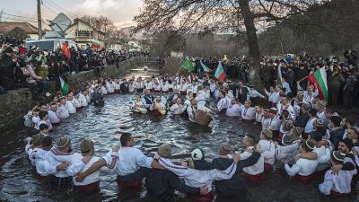 Bulgarians sing, play bagpipes and chaindance in the icy waters during Epiphany ritualin