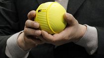 Hyun-Suk Kim, presidente e CEO della divisione Consumer Electronics di Samsung, tiene in mano Ballie, un robot rotante con intelligenza artificiale, durante un keynote di Samsung prima della fiera tecnologica CES, 2020.