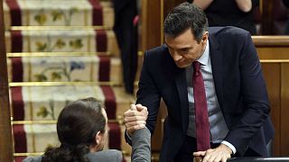 Le socialiste Pedro Sanchez, après son investiture, serrant la main de Pablo Iglesias, le chef de file de Podemos, le 7 janvier 2020 à la Chambre des députés à Madrid.