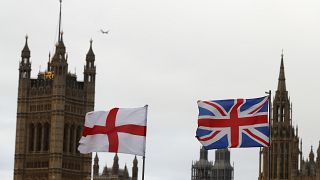 A British and an English flag wave in front of Houses of Parliament in London, Saturday, Dec. 14, 2019. 