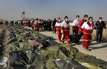 Rescue workers carry the body of a victim of an Ukrainian plane crash in Shahedshahr, southwest of the capital Tehran, Iran, Wednesday, Jan. 8, 2020.