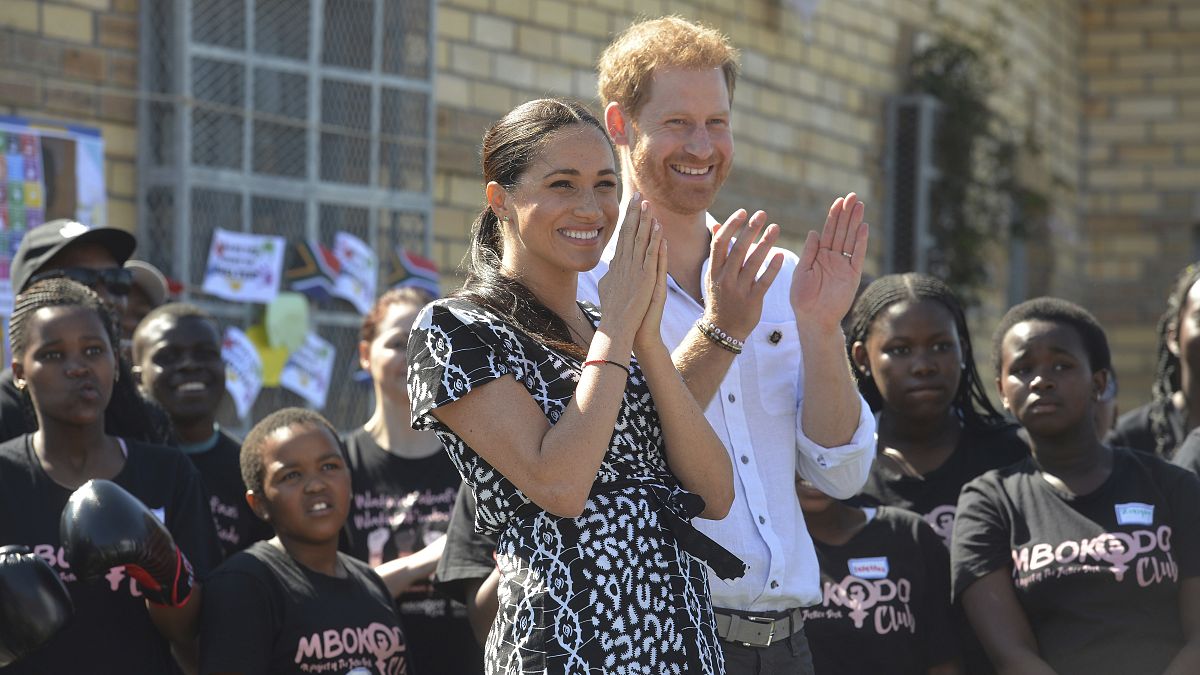 Britain's Prince Harry and Meghan, Duchess of Sussex greet youths on a visit to the Nyanga Methodist Church in Cape Town, South Africa on September 23, 2019.