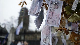 أوراق نقدية مزيفة قيمتها 350 جنيه استرليني، عليها وجه رئيس الحكومة البريطانية بوريس جونسون، وهي تتدلى من "شجرة المال السحرية" التي وضعها المتظاهرون المناهضون لـ"بريكست"