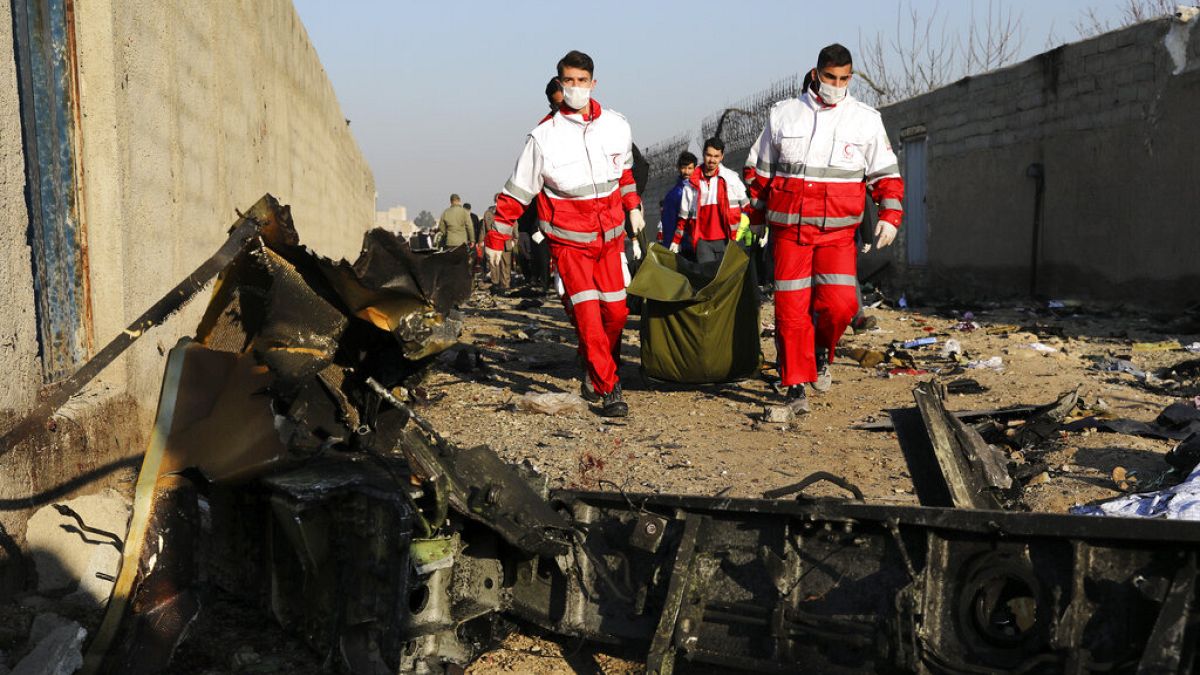 Rescue workers carry the body of a victim of an Ukrainian plane crash in Iran