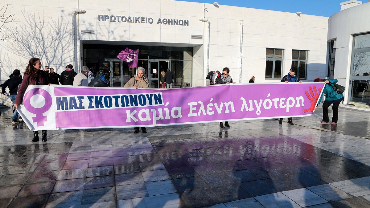 Μέλη φεμινιστικών οργανώσεων κρατούν πανό στο Μικτό Ορκωτό Δικαστήριο Αθηνών όπου ξεκίνησε η δίκη της υπόθεσης βιασμού και δολοφονίας της φοιτήτριας Ελένης Τοπαλούδη 