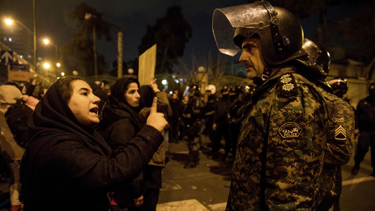 متظاهرة إيرانية تتحدث لأحد أفراد الأمن