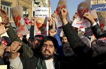 Hardline protesters chant slogans while holding up posters of Gen. Qassem Soleimani in front of British Embassy in Tehran, Iran, Sunday, Jan. 12, 2020