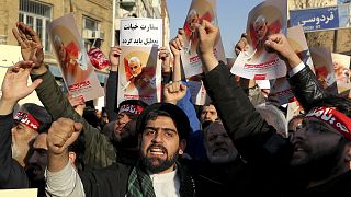 Hardline protesters chant slogans while holding up posters of Gen. Qassem Soleimani in front of British Embassy in Tehran, Iran, Sunday, Jan. 12, 2020