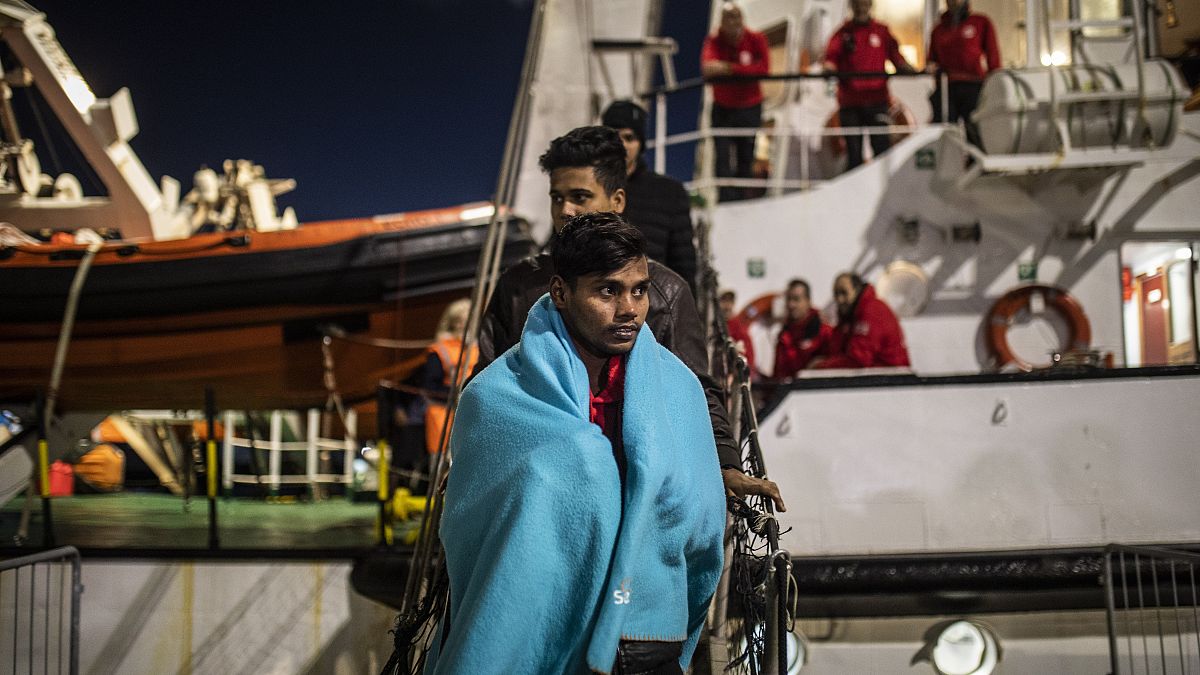 Migrantes de Bangladesh desembarcan del buque de rescate Open Arms en el puerto de Messina después de ser rescatados el viernes frente a la costa de Libia, en Sicilia, Italia