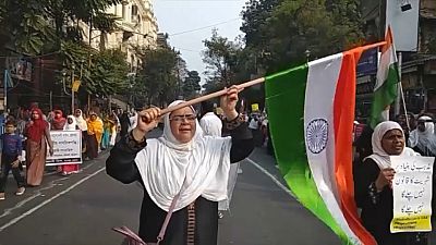 متظاهرة هندية ترفع العلم الهندي خلال مسيرة احتجاجية في كولكاتا