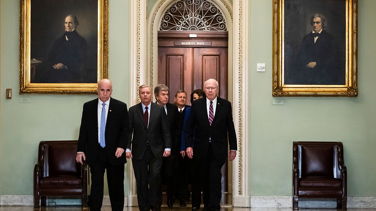 El presidente de la Corte Suprema John Roberts es escoltado por varios senadores hasta el pleno de la Cámara Alta, Washington, Estados Unidos, el 16 de enero de 2020.