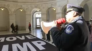Egy rendőr távozásra szólítja fel a tüntetőket a washingtoni szenátus épületében