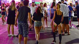 Tourists walk on the street at the resort of Magaluf, in Calvia town, on the Spanish Balearic island of Mallorca, Wednesday, June 10, 2015.