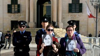 أفراد من عائلة الصحفية دافني كاروانا غاليزيا  وهن يحملن صورتها خلال احتجاج خارج مكتب رئيس الوزراء في في فاليتا، مالطا 2019