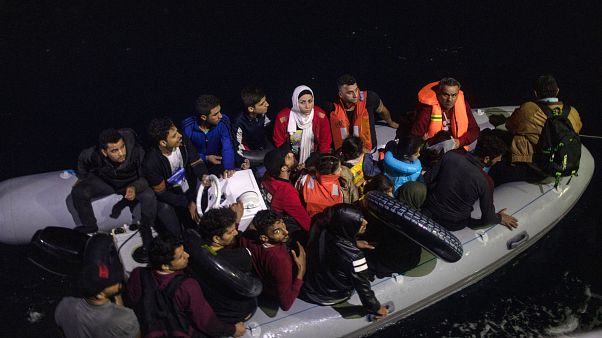 Refugees and migrants on a plastic boat approach a Greek Coast Guard ship in September 2019 Refugees and migrants on a plastic boat approach a Greek Coast Guard ship in September 2019
