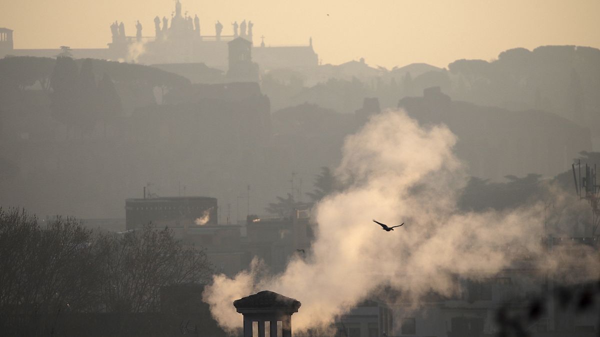Smoke billows from chimneys of residential buildings in Rome, Friday, Jan. 17, 2020. 
