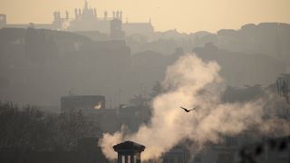 Smoke billows from chimneys of residential buildings in Rome, Friday, Jan. 17, 2020.