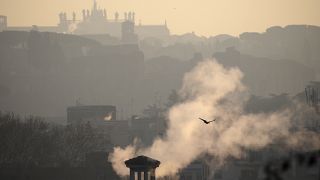 Smoke billows from chimneys of residential buildings in Rome, Friday, Jan. 17, 2020. 