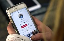 فتاة تحاول إدخال تطبيقات على هاتفها الذكي 