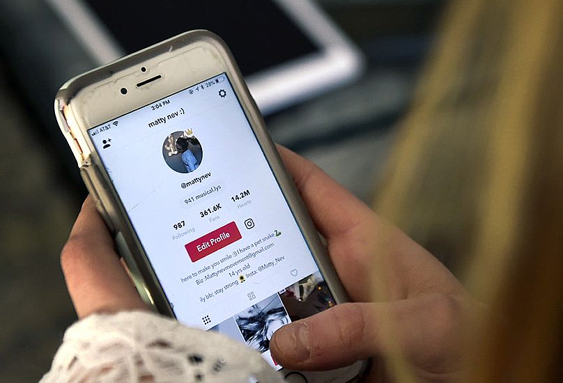 A teenage girl accesses social media on her mobile phone in Wethersfield, 28 February, 2018