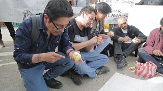 Men peel potatoes in Bolivia in campaign against sexist violence