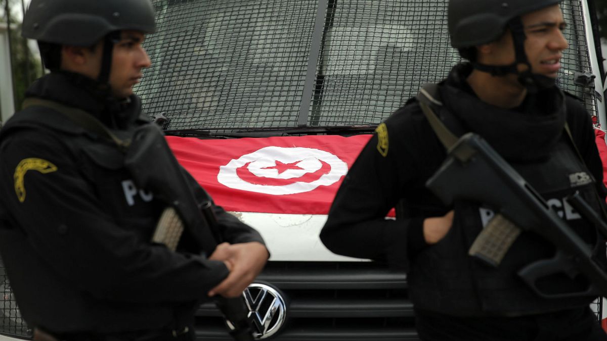 شرطيان تونسيان يقفان أم سيارتها في تونس العاصمة - (أرشيف 2015)
