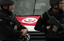 شرطيان تونسيان يقفان أم سيارتها في تونس العاصمة - (أرشيف 2015)