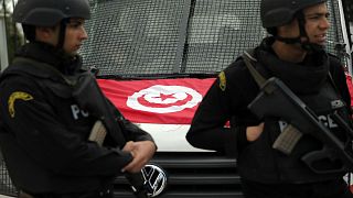 شرطيان تونسيان يقفان أم سيارتها في تونس العاصمة - (أرشيف 2015)