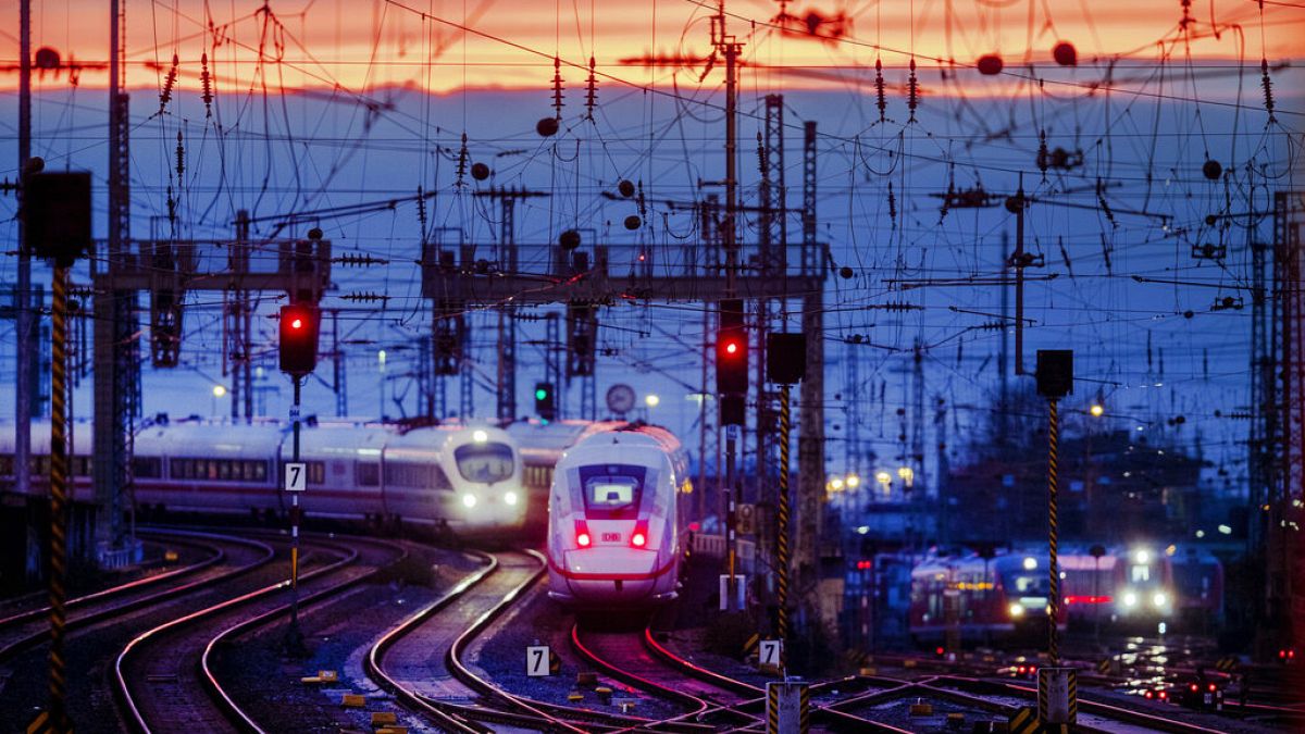 Two train approach the main train station after the sun set in Frankfurt, Germany, Friday, Jan. 17, 2020. (AP Photo/Michael Probst)