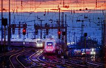 Two train approach the main train station after the sun set in Frankfurt, Germany, Friday, Jan. 17, 2020. (AP Photo/Michael Probst)
