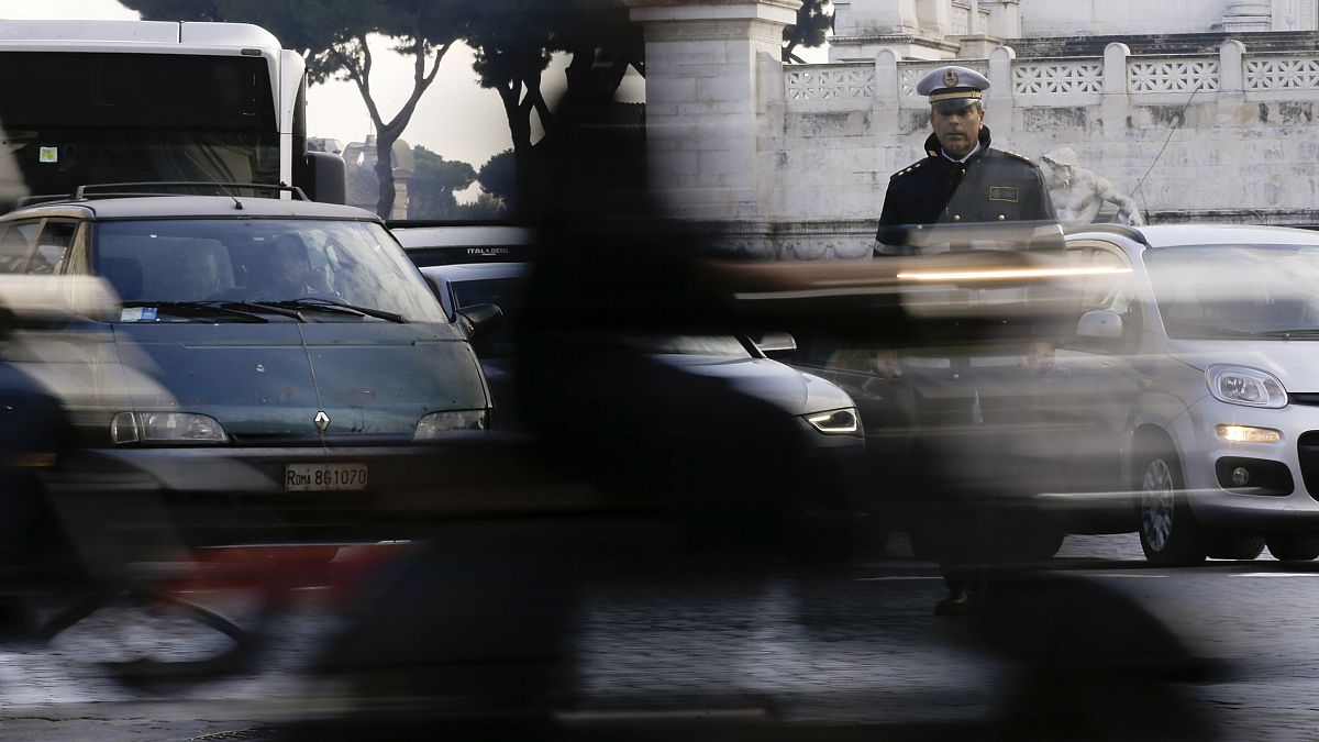 A City Police officer stands among cars as he directs traffic in downtown Rome, Thursday, Dec. 24, 2015.