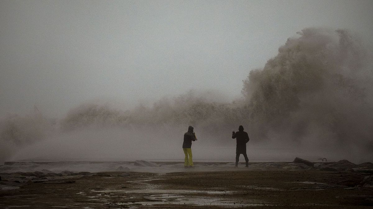 Una pareja contempla las olas en Barcelona durante la tormenta Gloria