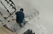 Mann schüppt Schneemassen vor seinem Haus