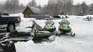 In this Dec. 10, 2014 photo, snowmobiles sit in the yard of Champlain Valley Motorsports in Cornwall, Vt.