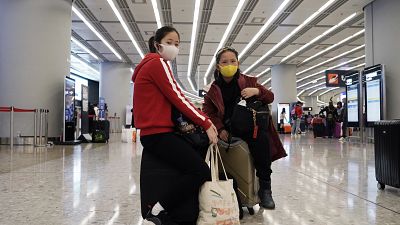 Hong Kong'daki tren istasyonunda yeni koronavirüse karşı maske takan insanlar 