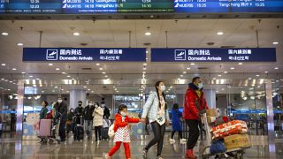 Pekin Uluslararası Havaalanı'ndaki yolcular da virüse karşı maske taktı